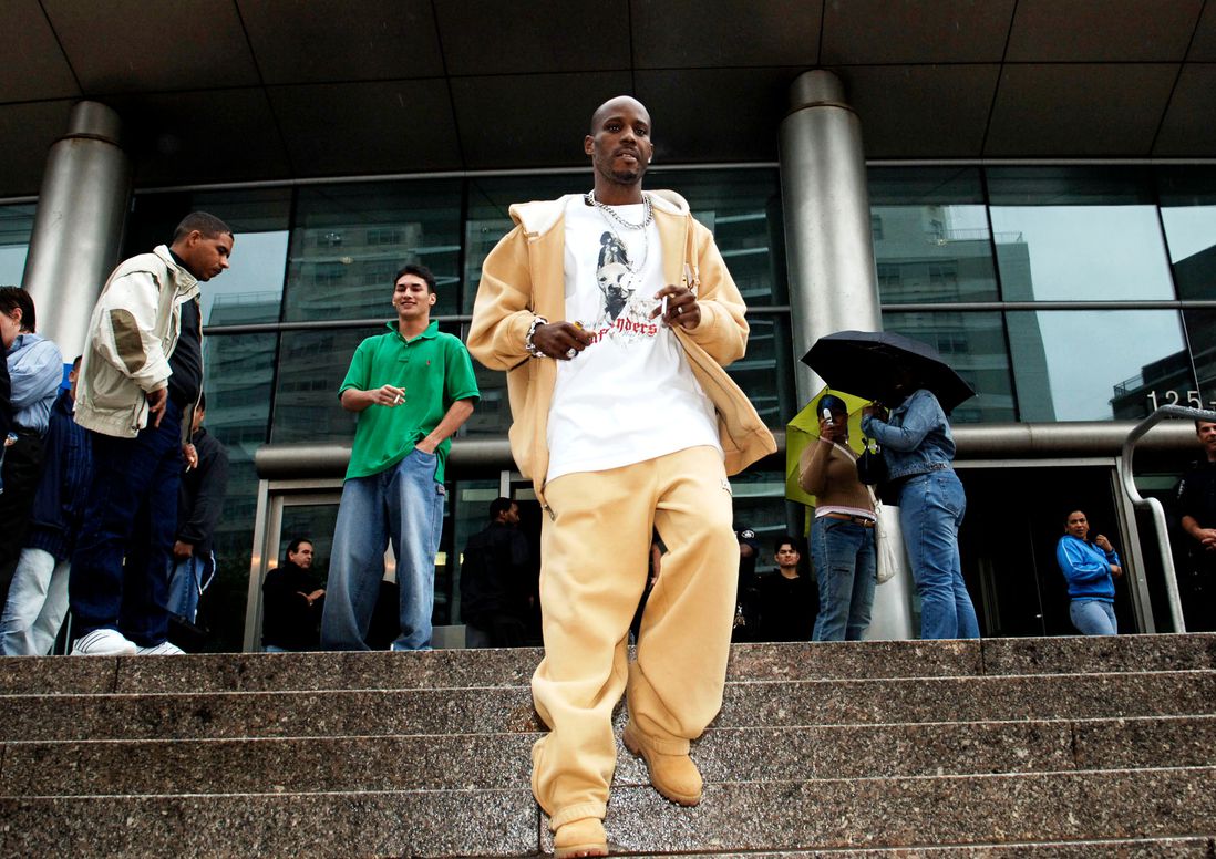 DMX in a yellow jacket and matching pants and t-shirts walks down a set of stairs